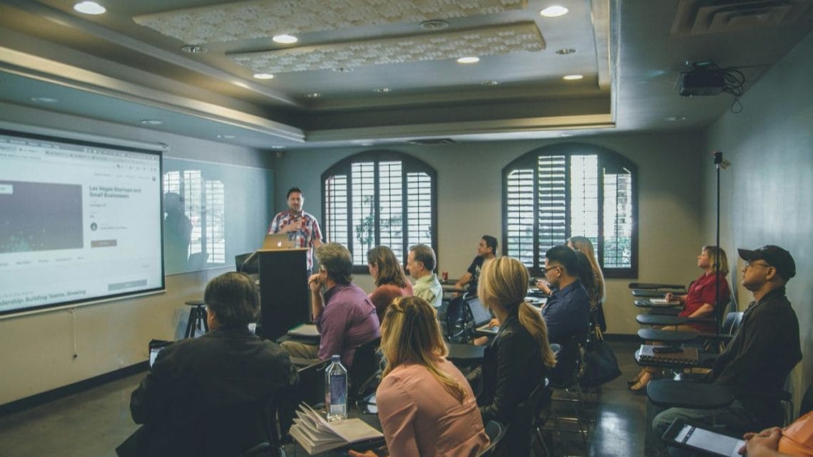 employees gathered in a room listening to a presentation